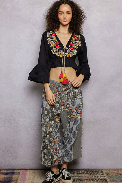 Black floral embroidered cropped blouse from Trendsi featuring intricate embroidery and a stylish, fitted design.