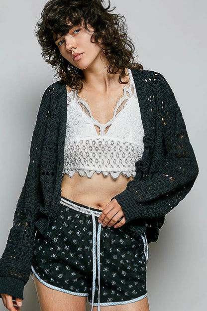 Black POL open-knit floral button cardigan by Trendsi featuring a lightweight knit and decorative floral pattern.