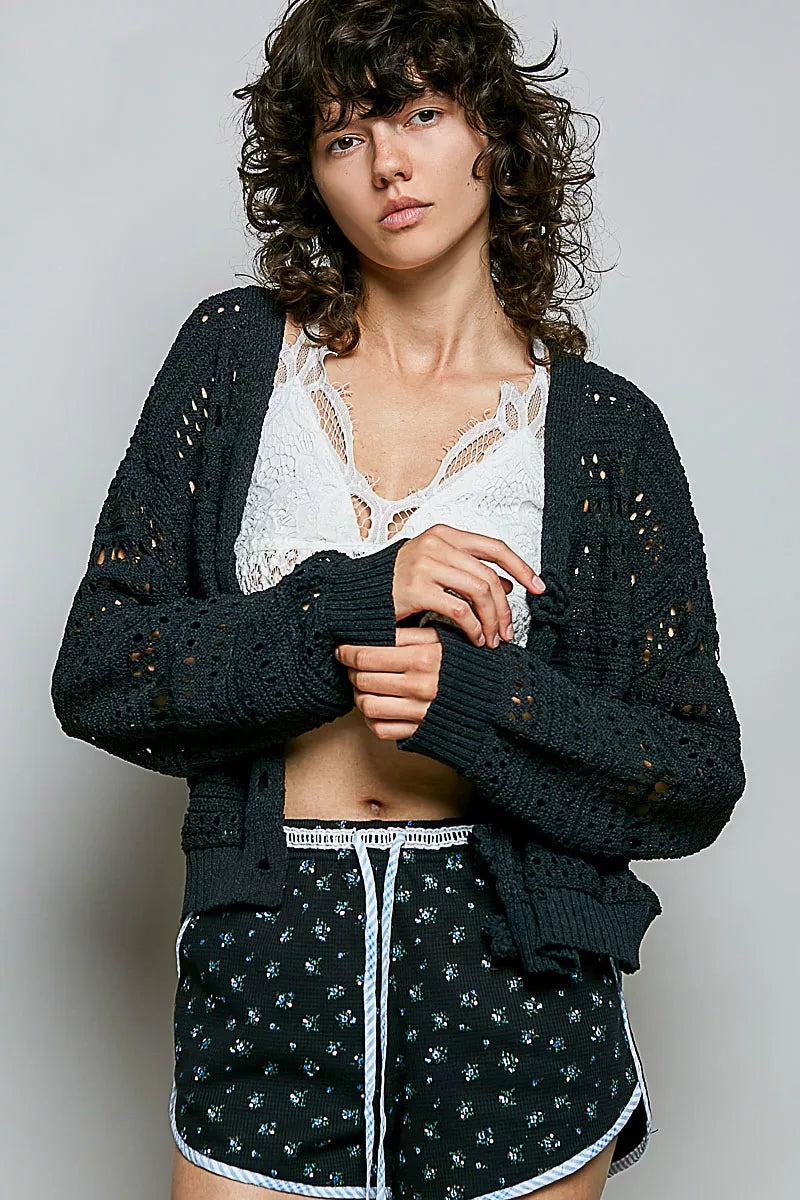 Black POL open-knit floral button cardigan by Trendsi, featuring a lightweight knit with floral patterns and button closure.