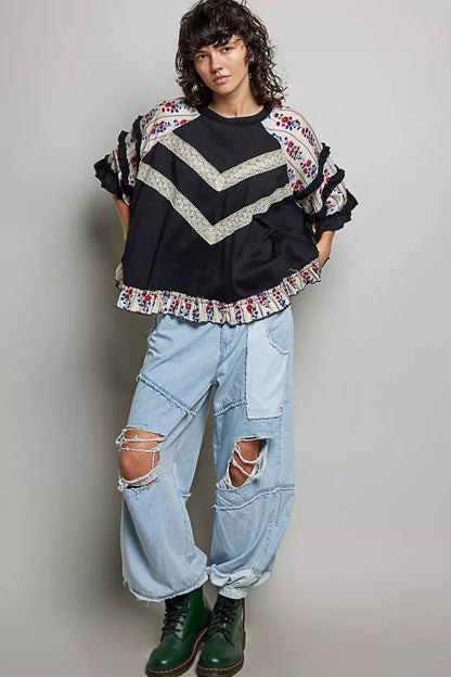 Black oversized knit top by Trendsi featuring a round neck, half sleeves, contrast floral lace details, and a relaxed fit.