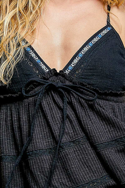 Black V-neck embroidered trim ruffled camisole by Trendsi, featuring delicate embroidery and feminine ruffle details.