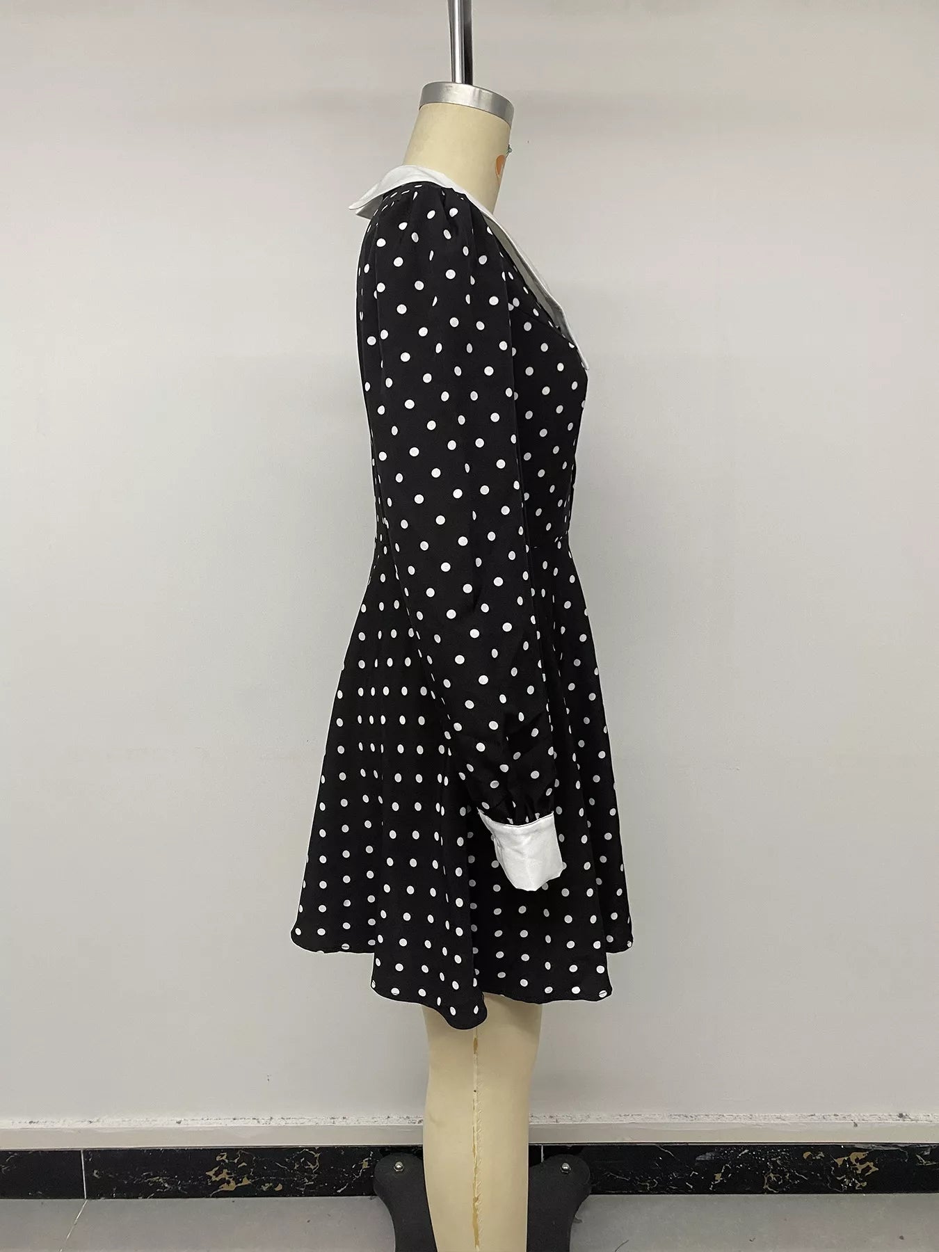 Black polka dot Peter Pan collar dress by Trendsi featuring a fitted bodice and playful, vintage-inspired design.