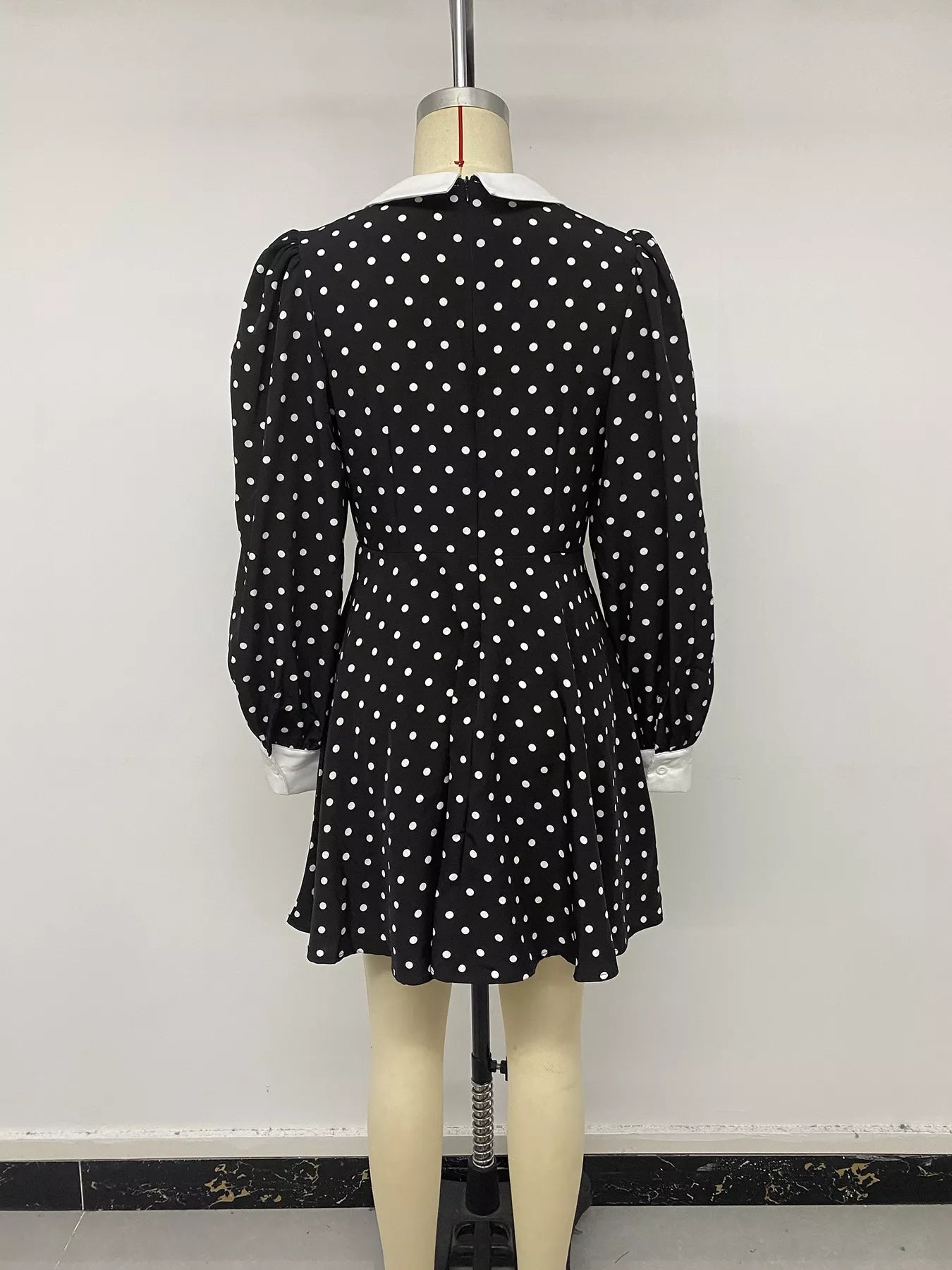 Black polka dot Peter Pan collar dress by Trendsi, featuring a fitted design with a classic collar and playful polka dot pattern.