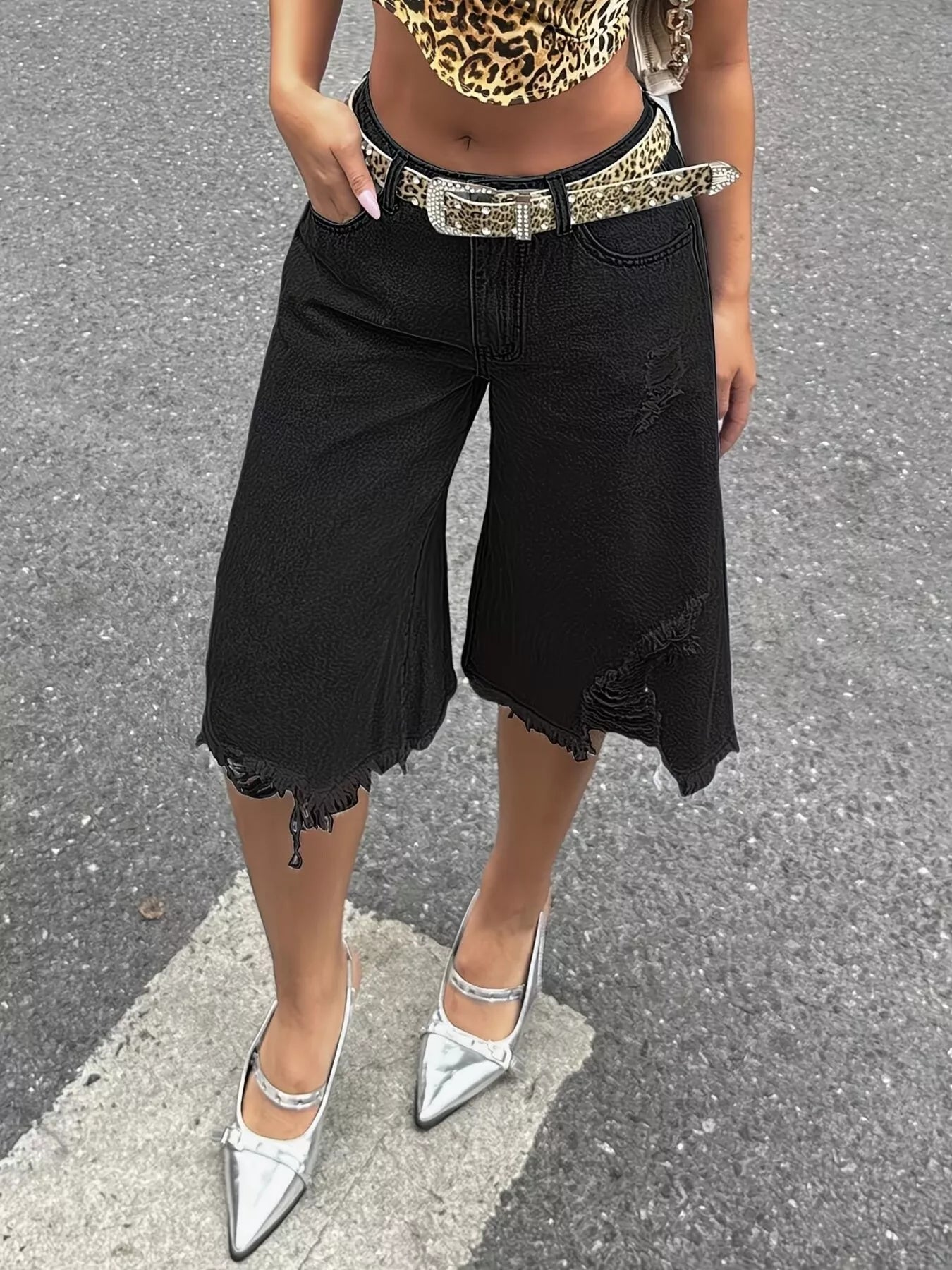 Black raw hem distressed denim shorts by Trendsi, featuring frayed edges and a casual fit, displayed on a white background.