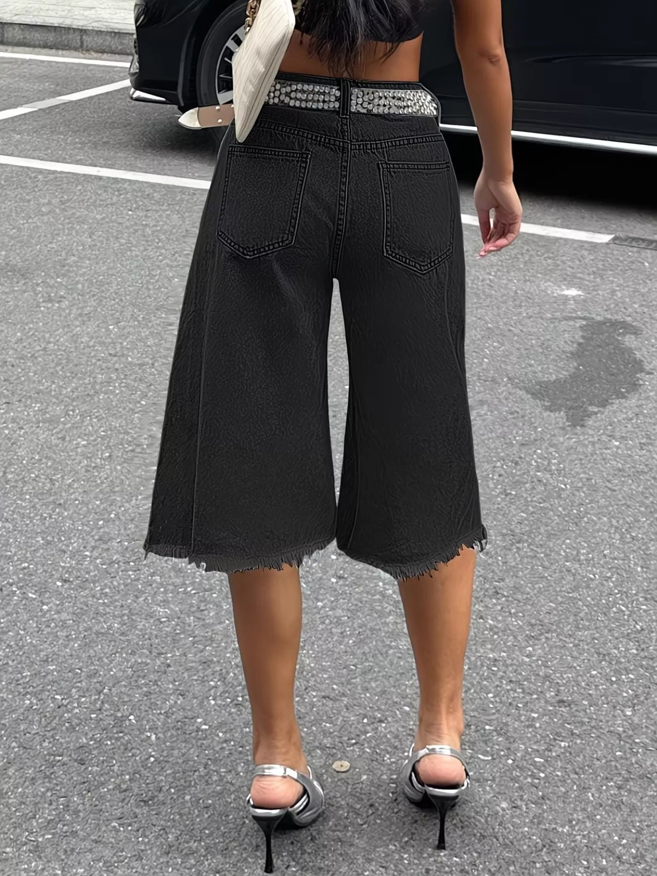 Black raw hem distressed denim shorts by Trendsi, featuring frayed edges and a casual fit for a trendy summer look.
