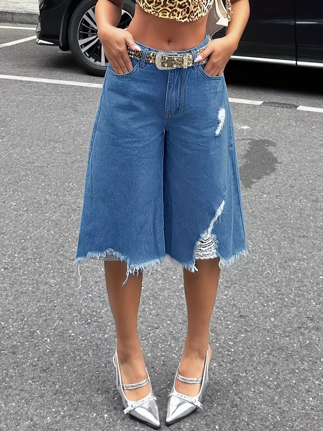 Black raw hem distressed denim shorts by Trendsi, featuring frayed edges and a casual fit, shown on a model.