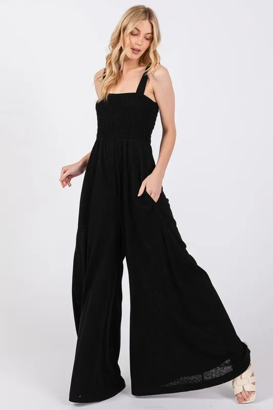 Black Sage+Fig smocked flowy wide-leg jumpsuit with relaxed fit and adjustable straps, perfect for casual and stylish looks.