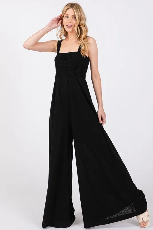Black Sage+Fig smocked flowy wide-leg jumpsuit from Trendsi, featuring a relaxed fit and stylish design.