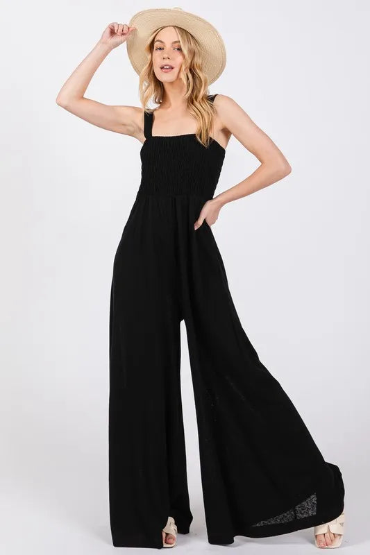 Black Sage+Fig smocked wide-leg jumpsuit featuring flowy fabric and relaxed fit, perfect for casual and stylish wear.