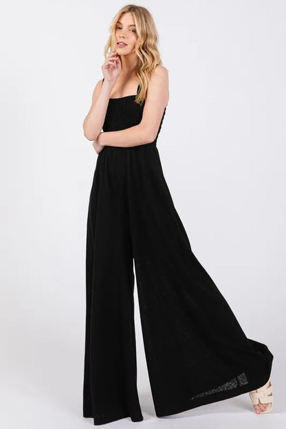 Black Sage+Fig smocked flowy wide-leg jumpsuit from Trendsi, featuring a relaxed fit and elegant design.