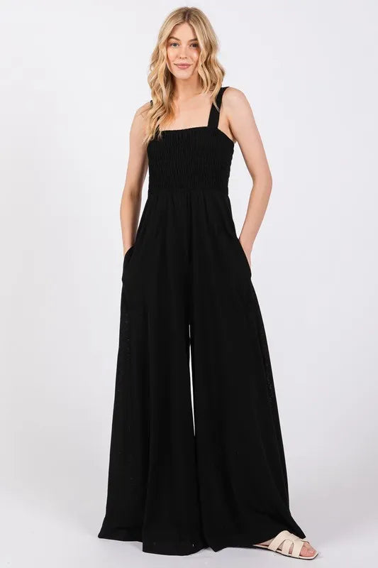 Black Sage+Fig smocked flowy wide leg jumpsuit from Trendsi, featuring a relaxed fit and stylish design.