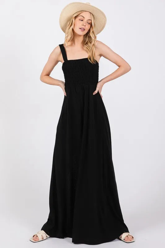 Black Sage+Fig smocked flowy wide-leg jumpsuit with relaxed fit and adjustable straps, perfect for casual or summer wear.