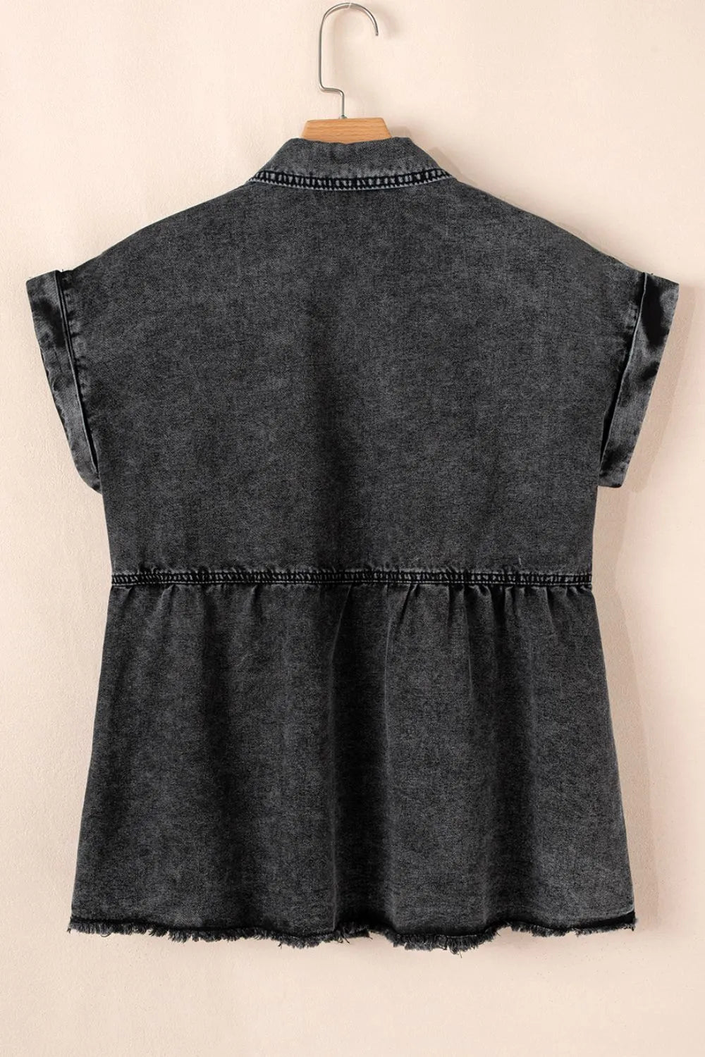 Black short sleeve denim shirt by Trendsi with flap pockets, button-up front, and raw hem, displayed on a plain background.