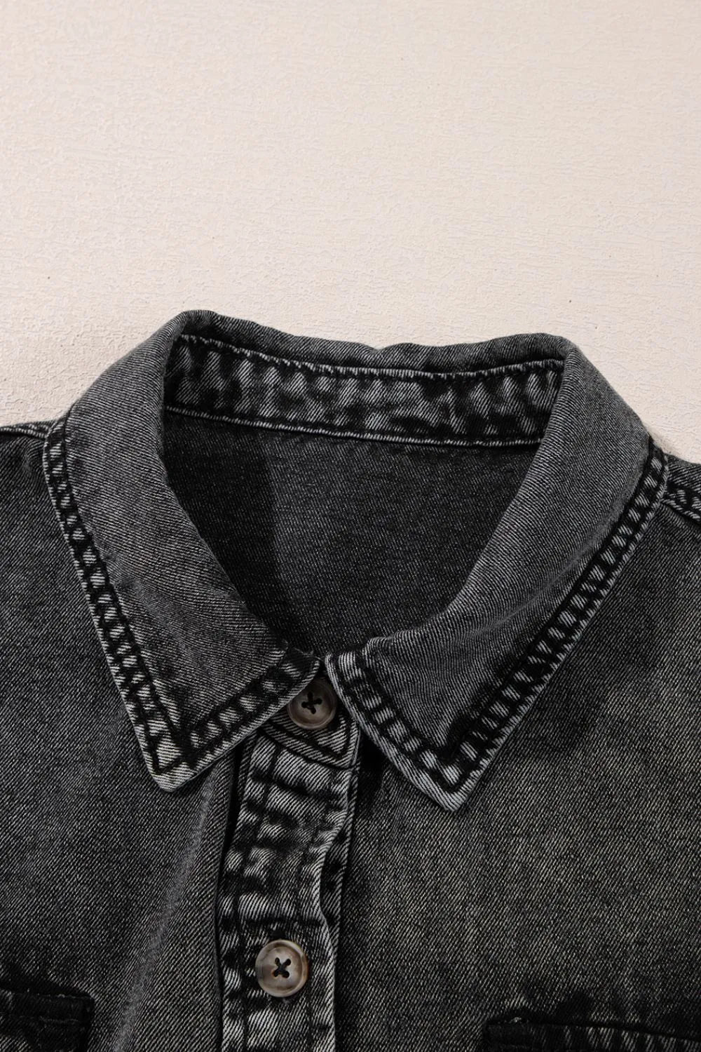 Black short sleeve denim shirt with flap pockets, button-up front, and raw hem by Trendsi