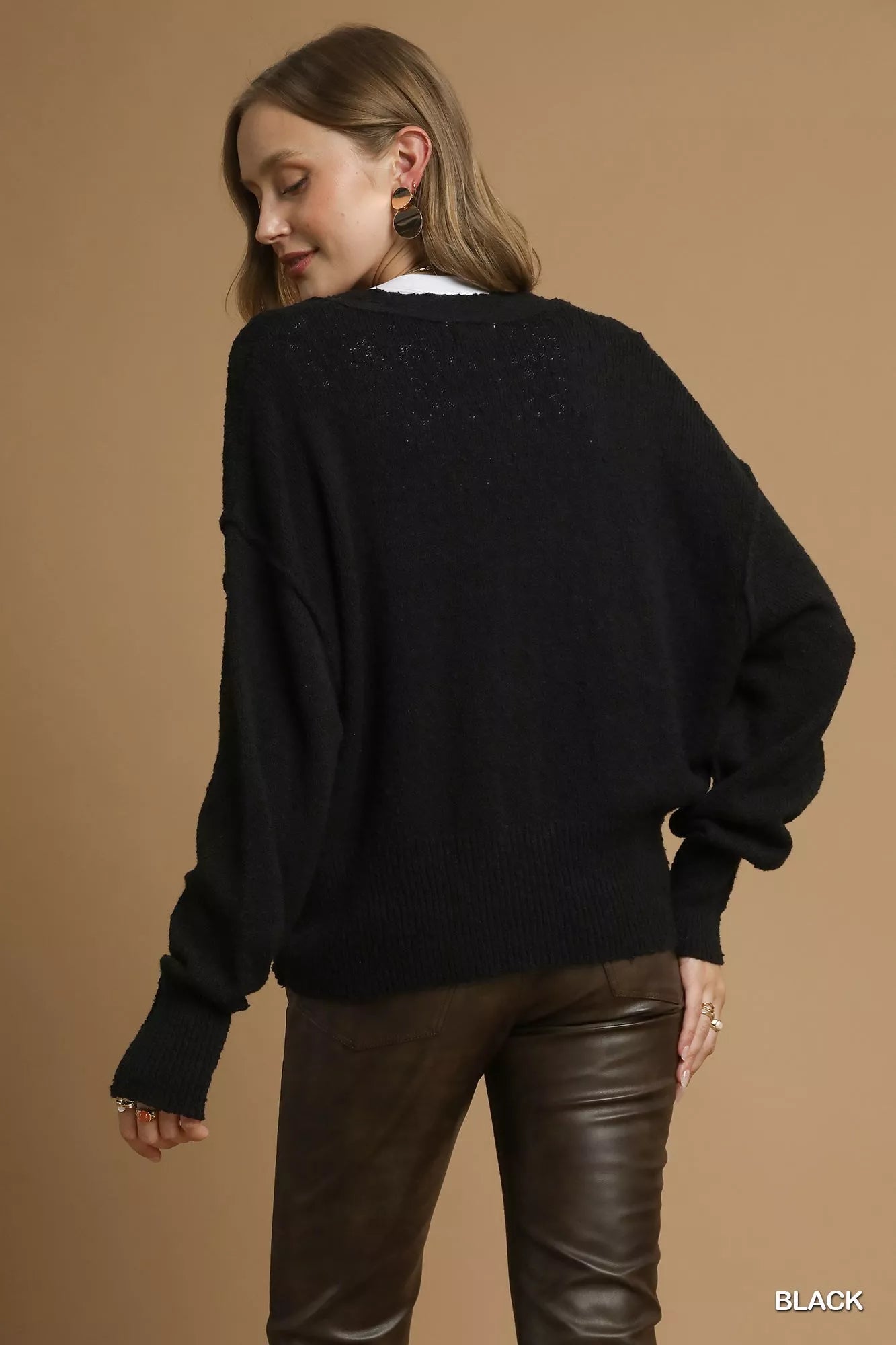Black Umgee button-front V-neck knit cardigan with long sleeves and ribbed hem, styled on a hanger.