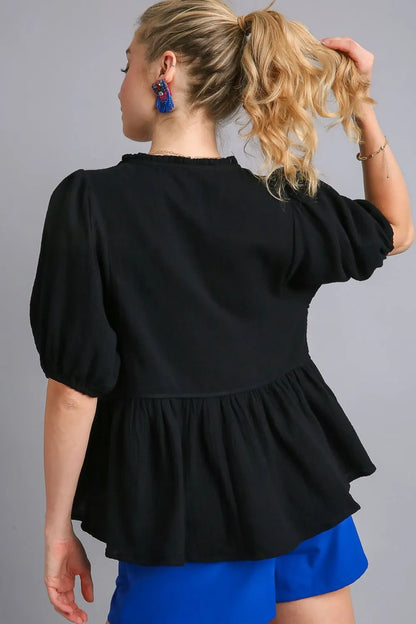 Black plus size Umgee babydoll blouse with cotton gauze fabric and floral embroidery, showcasing a relaxed fit and flowing style.