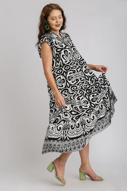 Plus size Umgee black midi dress with two-tone border print, ruffle cap sleeves, and a stylish flowy silhouette.