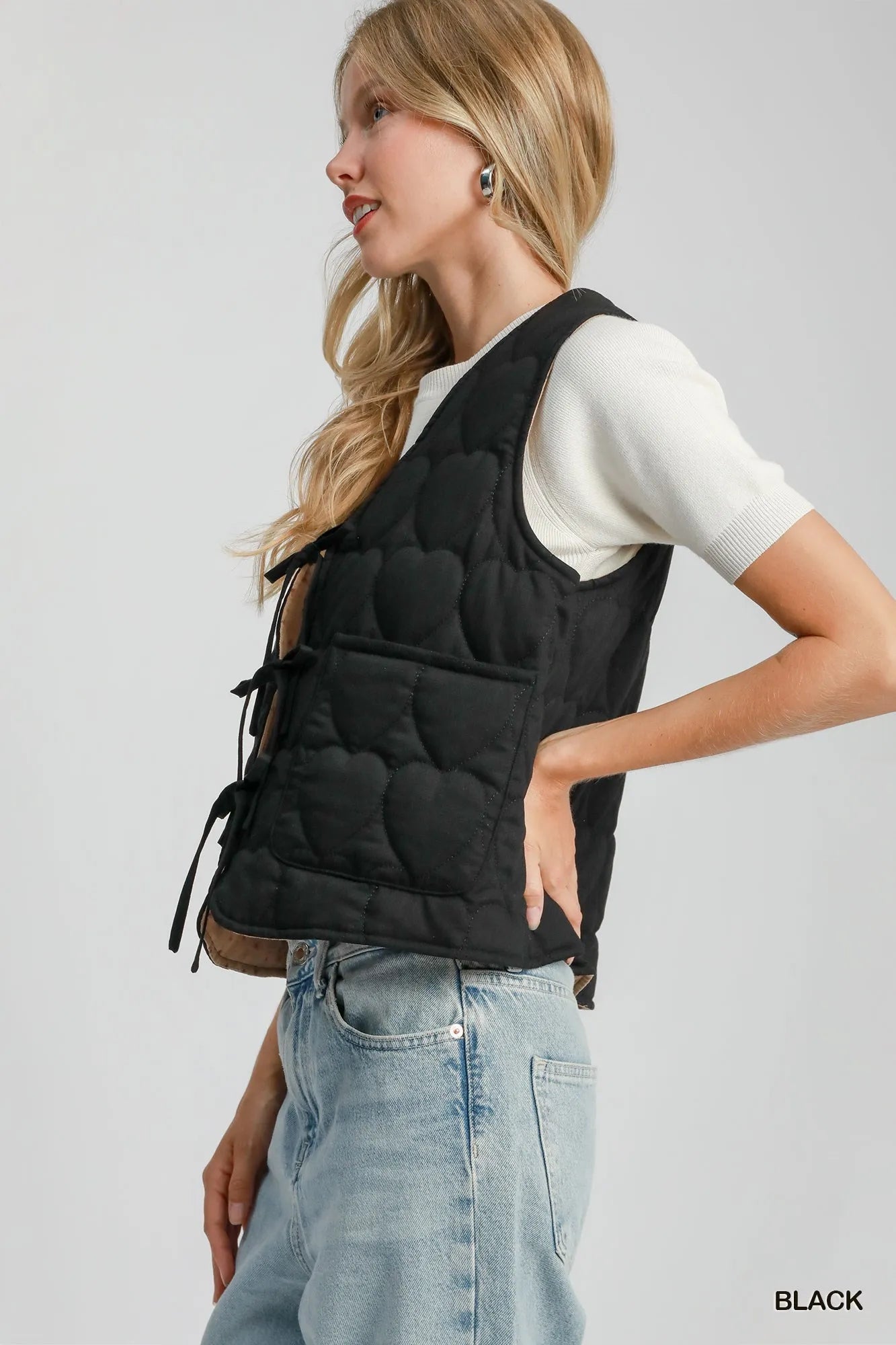 Black Umgee Heart Quilted Tie-Front Vest with front tie closure and quilted pattern, styled for a casual, layered look.