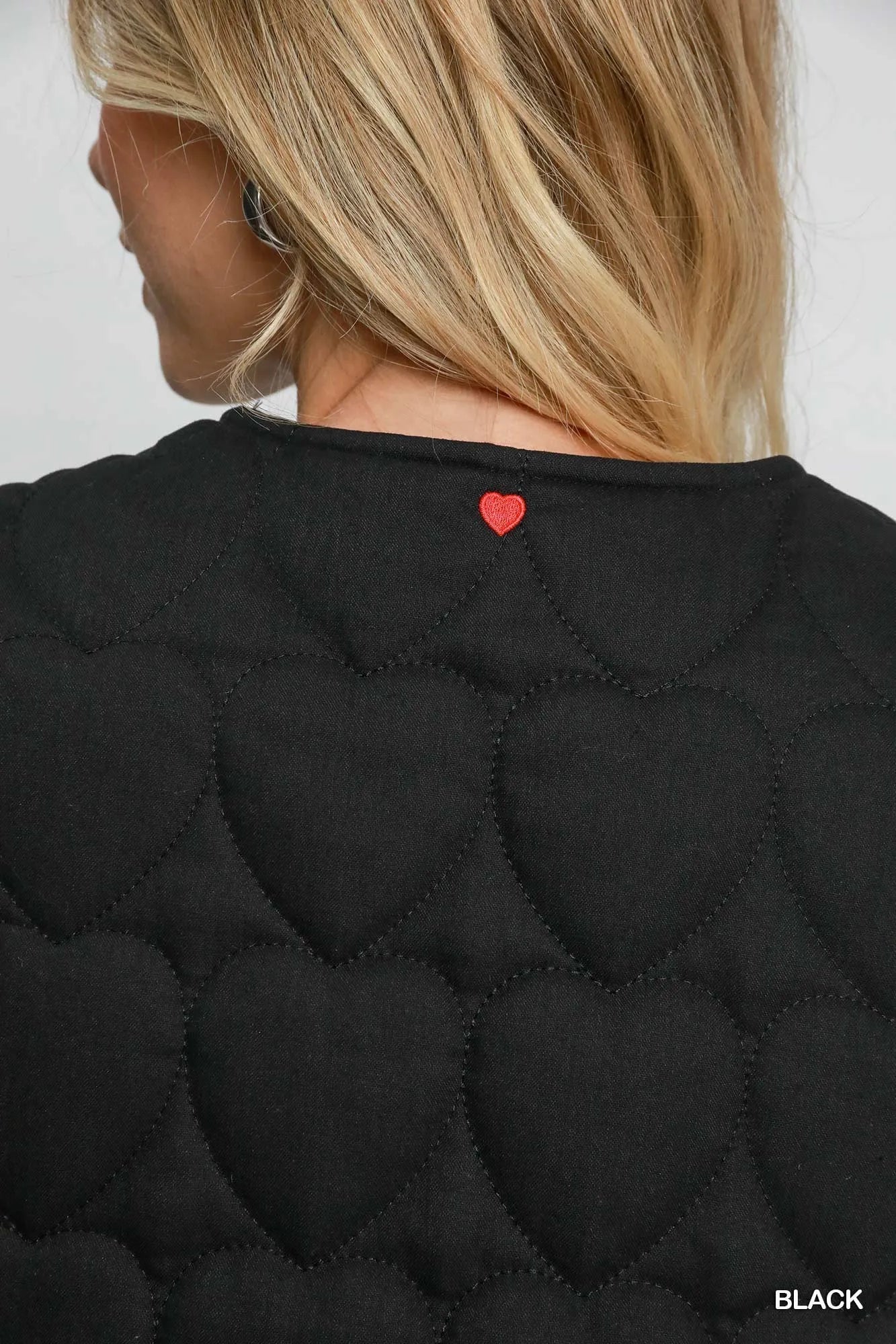 Black Umgee Heart Quilted Tie-Front Vest with front tie and quilted pattern, styled with a casual look.