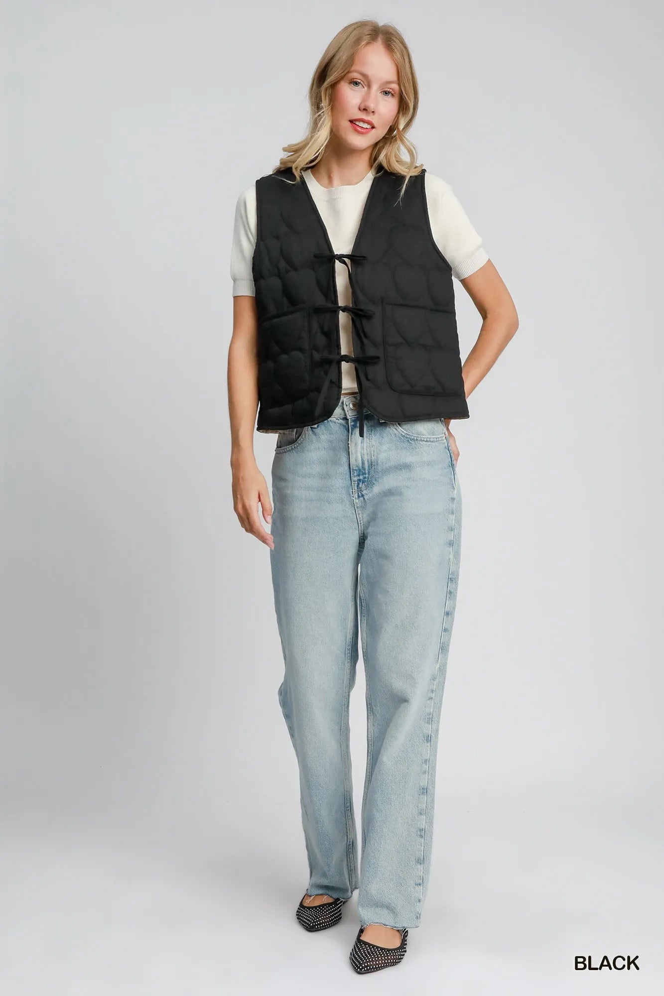 Black Umgee Heart Quilted Tie-Front Vest with front tie detail, styled with a cozy, patterned fabric for casual wear.