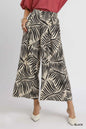 Black Umgee palm leaf print wide-leg culotte pants with a relaxed fit and high waist, perfect for casual or summer wear.