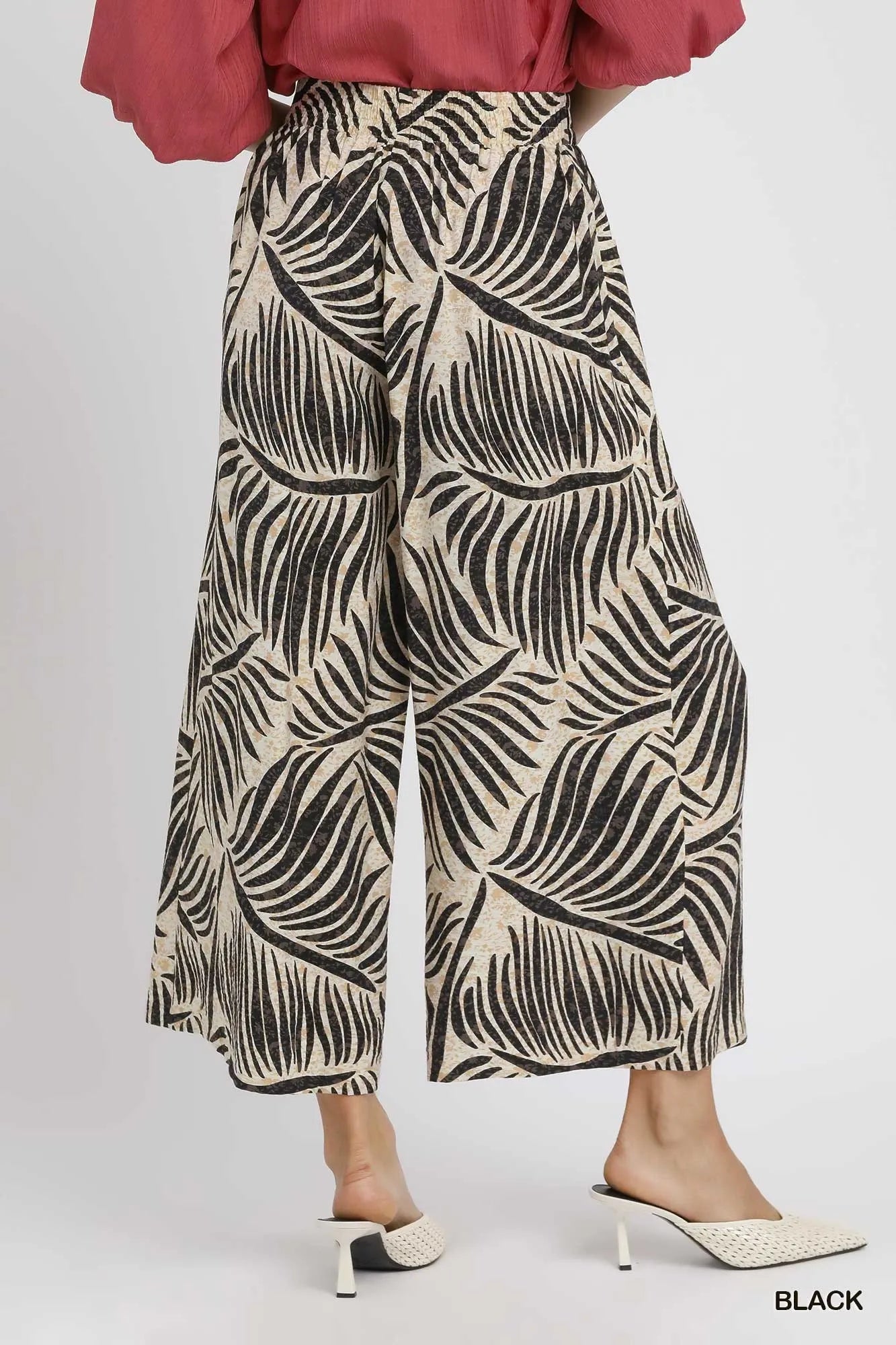 Black Umgee palm leaf print wide-leg culotte pants with a relaxed fit and flowy fabric, perfect for casual or summer wear.