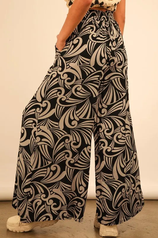 Plus size black printed wide-leg pants by Trendsi, featuring a comfortable full-length fit and stylish design.