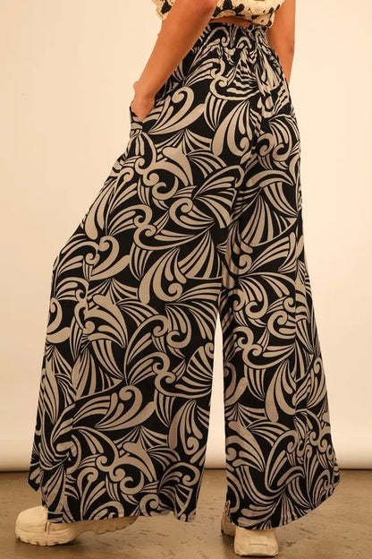 Plus size black printed wide-leg pants by Trendsi, featuring a comfortable full-length fit and stylish design.