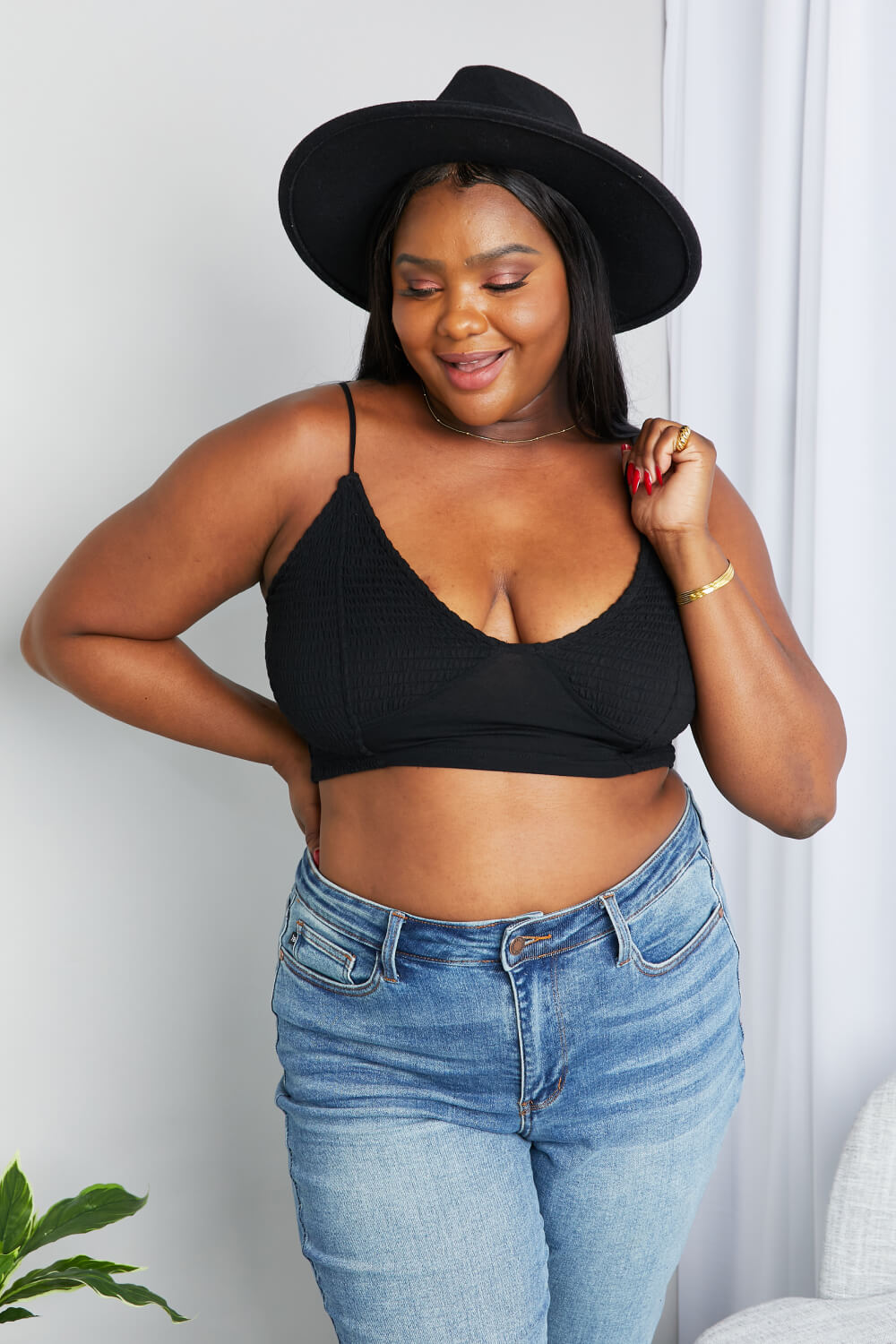 Black Zenana full-size textured spaghetti strap bralette with soft fabric and adjustable straps, laid flat.
