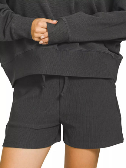 Black Zenana ribbed round neck pullover and shorts set from Trendsi, displayed flat with fabric texture visible.