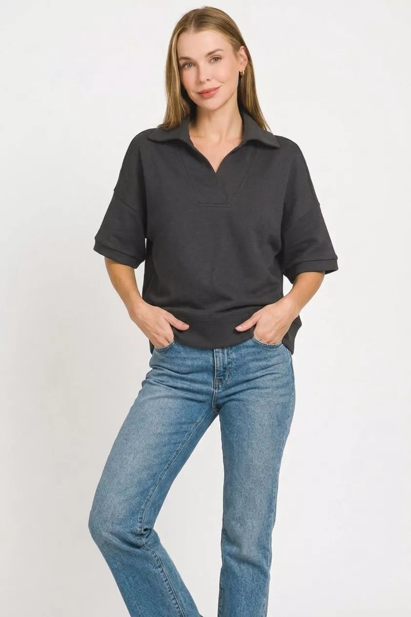 Black Zenana scuba collared short sleeve pullover from Trendsi, featuring a fitted design and comfortable fabric.
