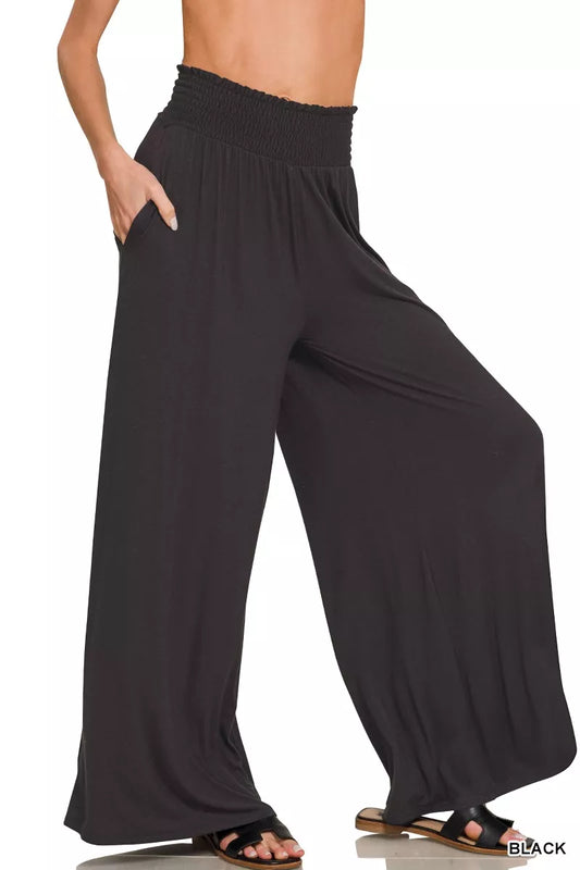 Black Zenana smocked waist wide-leg palazzo pants with flowing fabric and relaxed fit, showcased on a model.