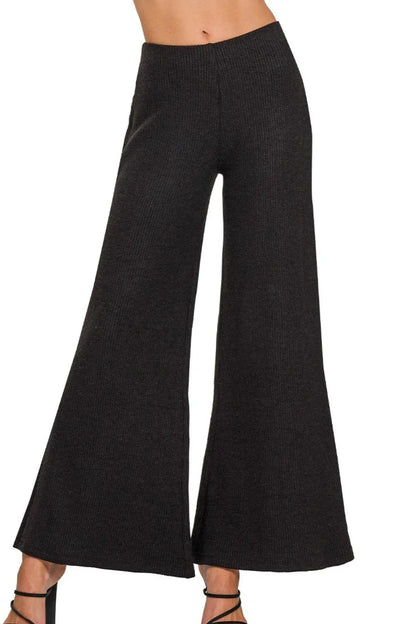 Black Zenana wide-leg flare sweater pants by Trendsi, shown with a relaxed fit and ribbed waistband.