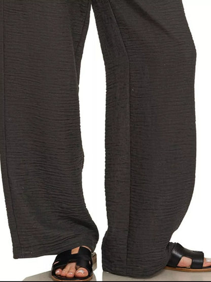 Black Zenana woven crepe pants with elastic waistband, shown on a model, featuring a relaxed fit and stylish design.