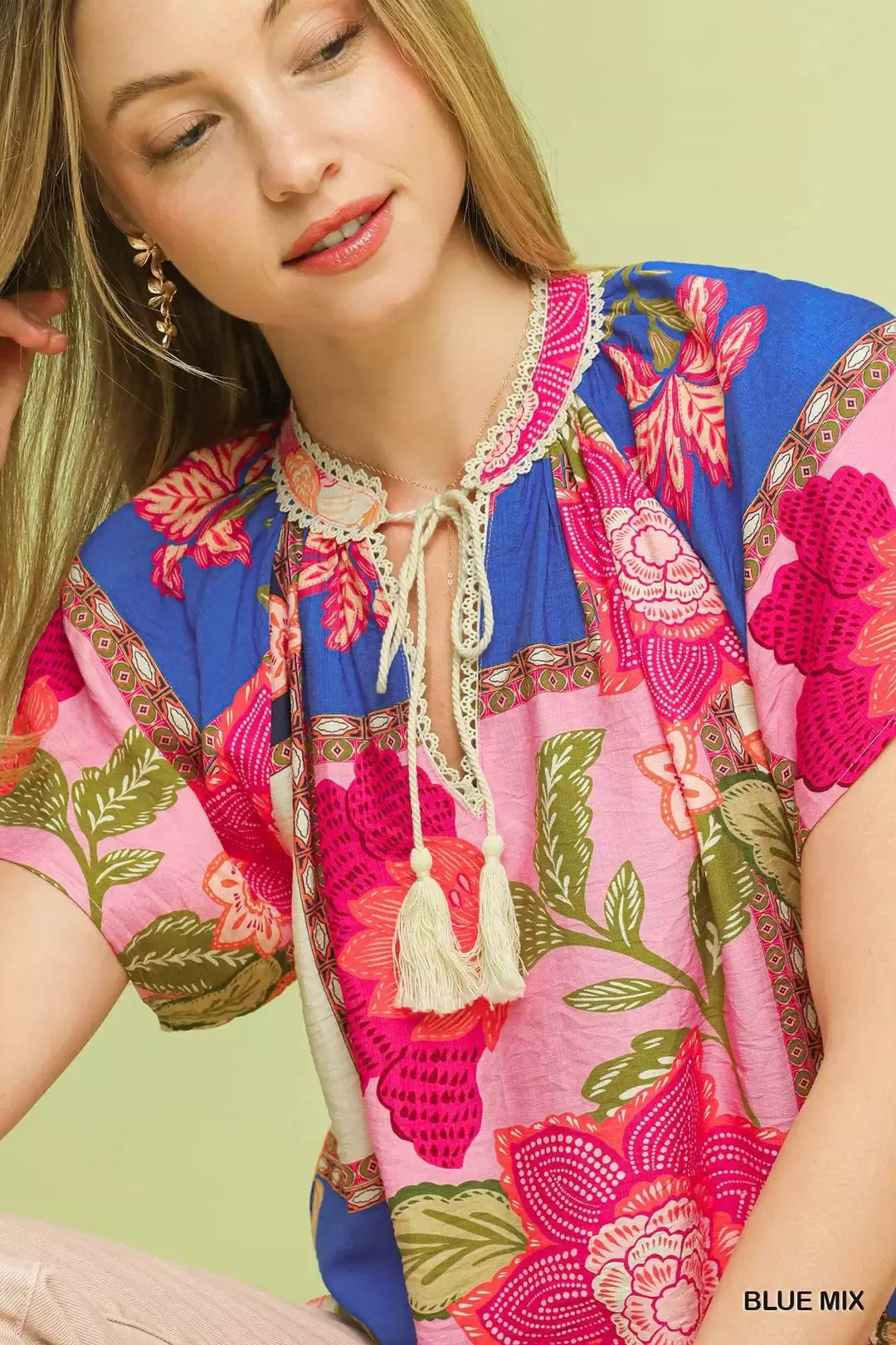 Blue floral patchwork tassel tie top by Umgee featuring mixed fabric patterns and a relaxed fit, styled with tassel accents.