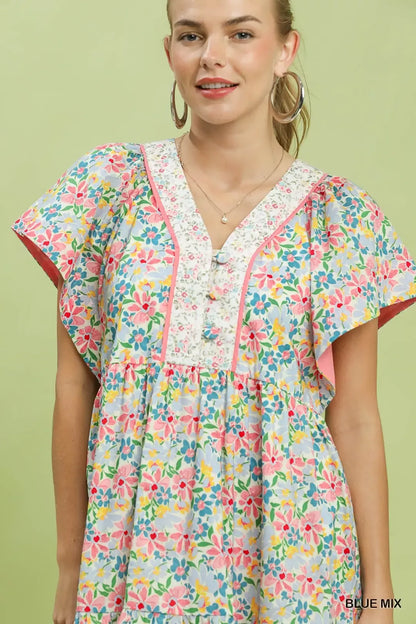 Blue Umgee floral tiered mini dress with side pockets, featuring a mix of floral patterns and a casual, flowy silhouette.
