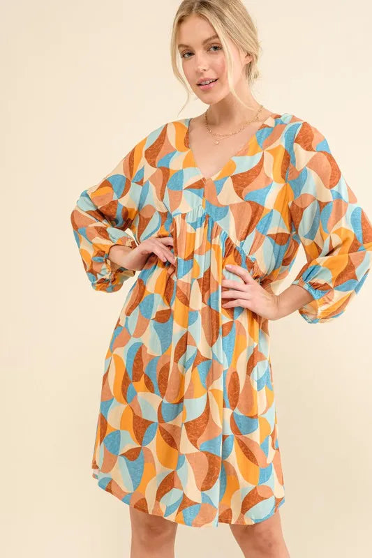 Blue multi printed open-back casual dress with puff sleeves by Trendsi, featuring a relaxed fit and stylish design.