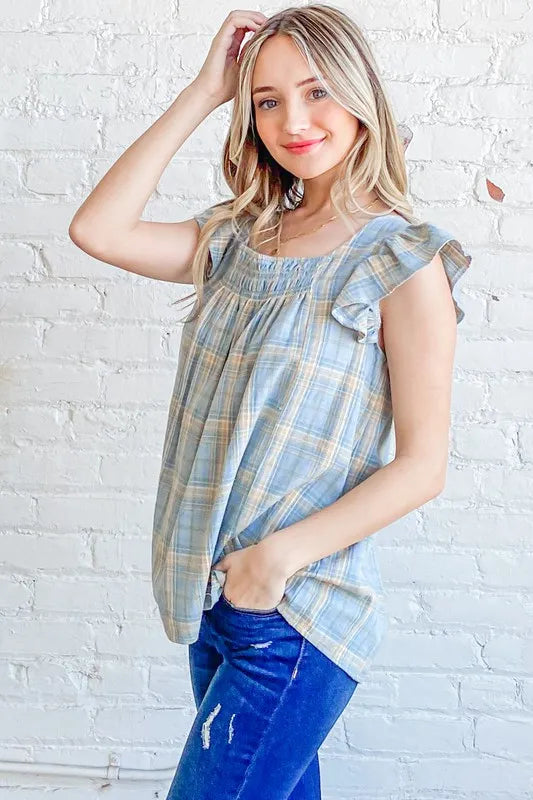 Blue plaid print baby doll top with smocked detail and ruffle accents from Trendsi's And The Why collection.