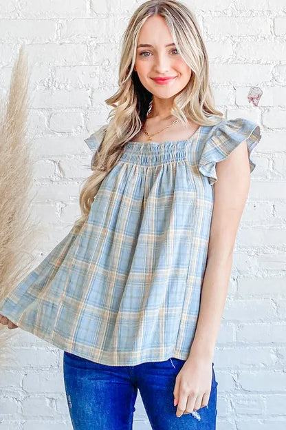 Blue plaid print baby doll top with smocked detail and ruffle accents, trendy blouse from And The Why by Trendsi.