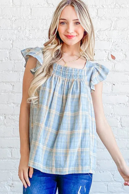 Blue plaid print baby doll top with smocked detail and ruffle accents, from Trendsi's And The Why collection.