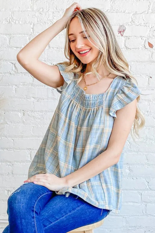 Blue plaid print baby doll top by Trendsi featuring smocked details and ruffle accents, perfect for a charming, casual look.