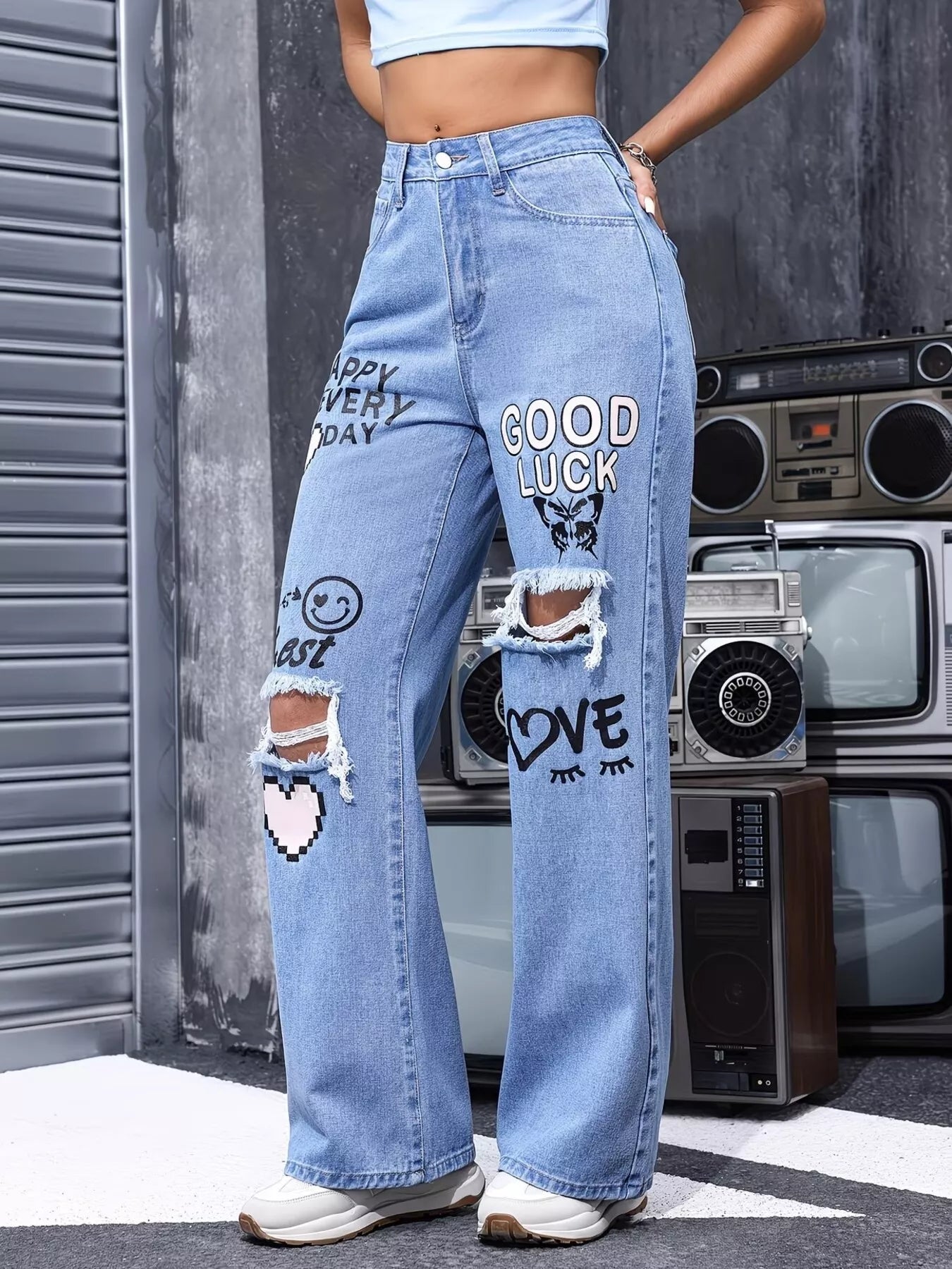 Blue distressed printed wide-leg jeans from Trendsi featuring rips, fading, and relaxed fit for casual style.