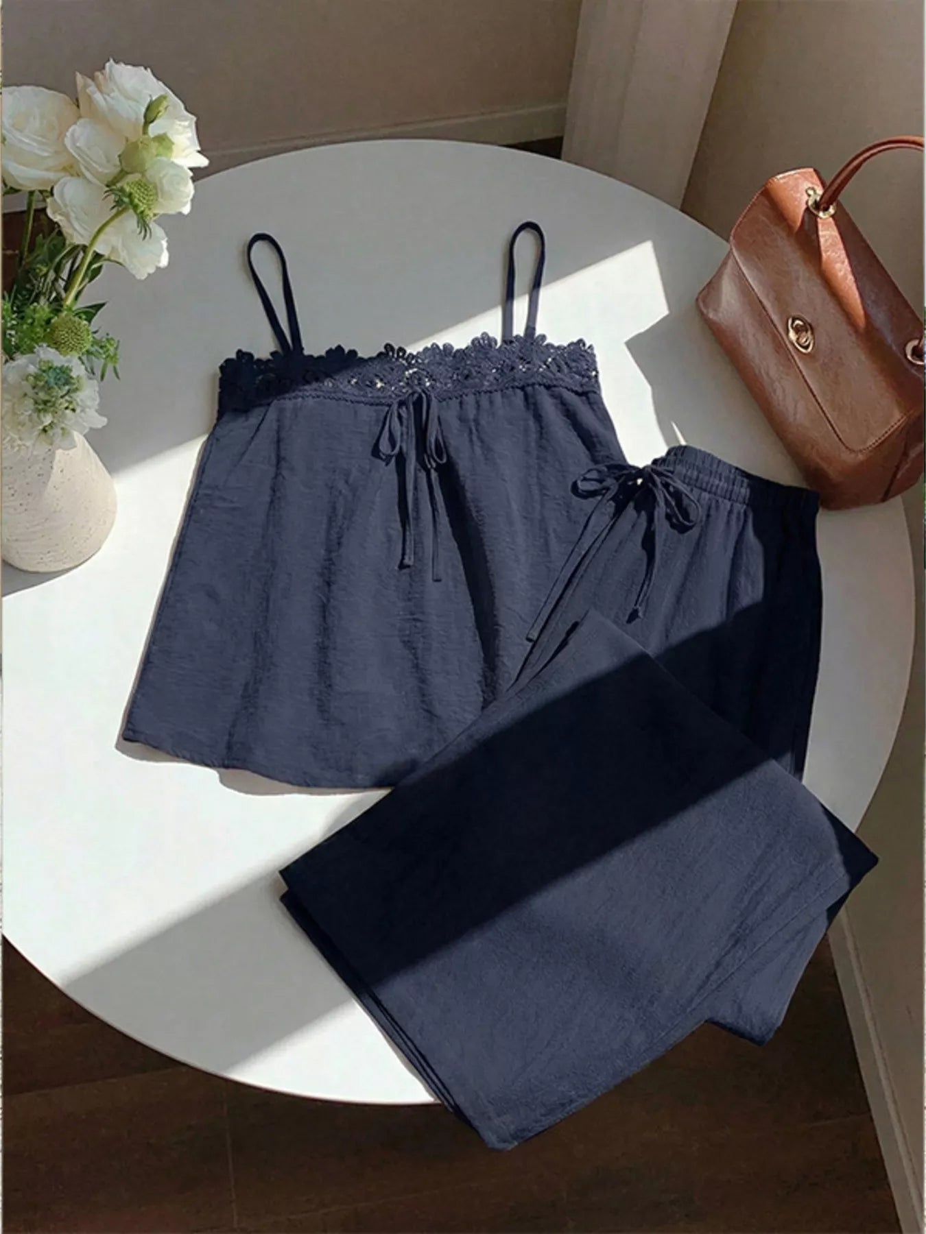 Blue lace trim cami and wide-leg pants set from Trendsi, featuring a stylish, comfortable matching top and pants ensemble.