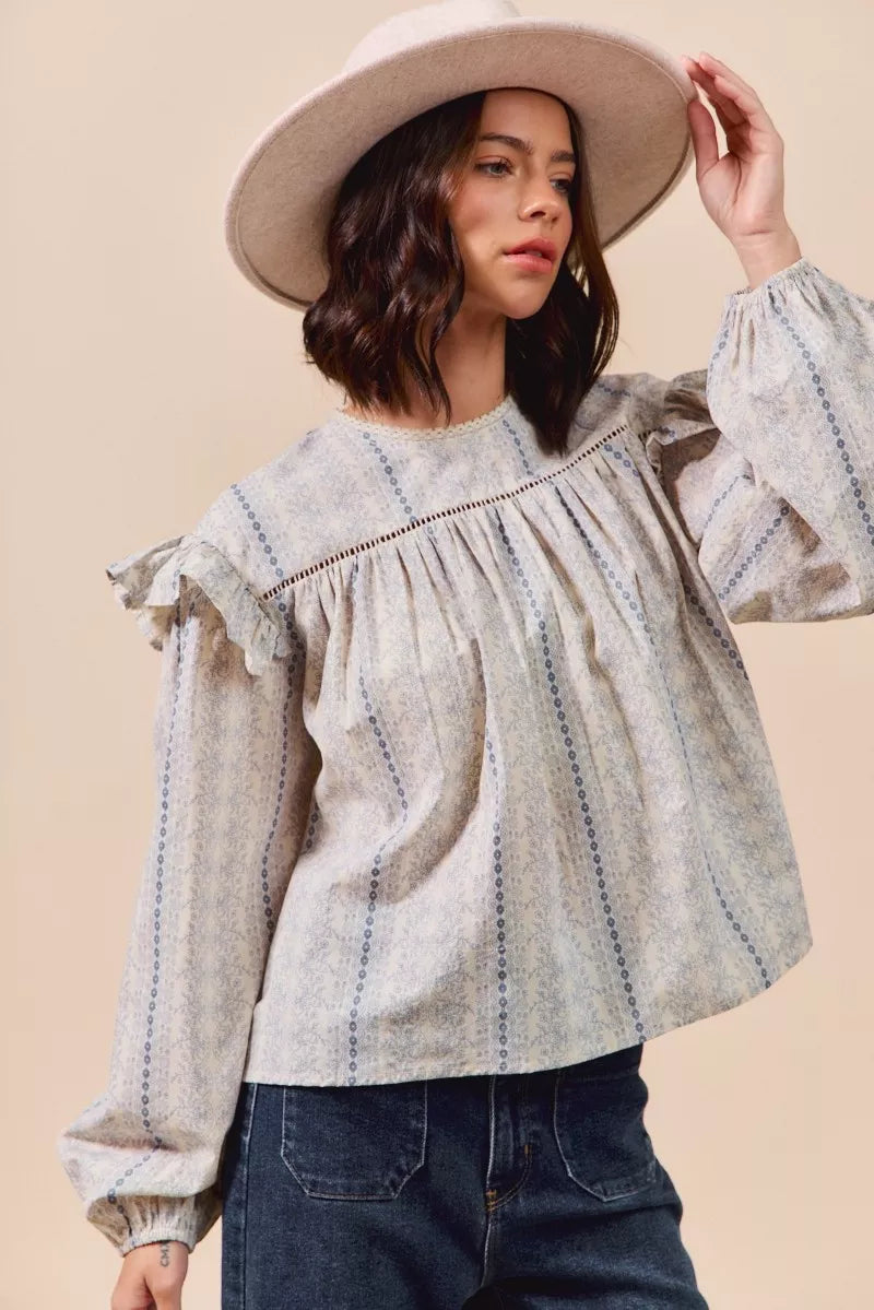 Blue floral cotton print ruffled long sleeve blouse from SO ME by Trendsi, featuring a feminine design and ruffled cuffs.