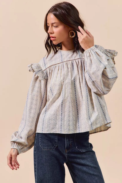 Blue floral cotton print ruffled long sleeve blouse by Trendsi with feminine design and detailed ruffle accents.