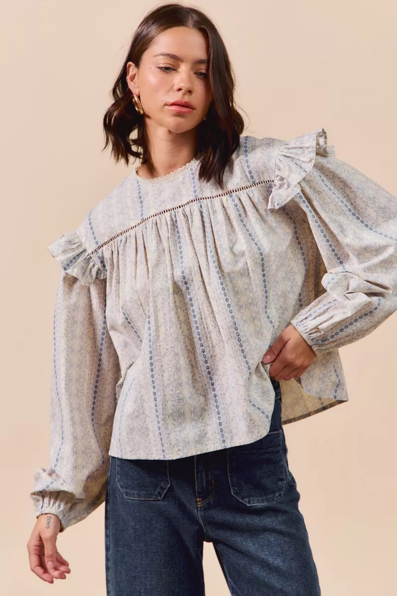 Blue floral cotton print ruffled long sleeve blouse by Trendsi, featuring a feminine design and lightweight fabric.
