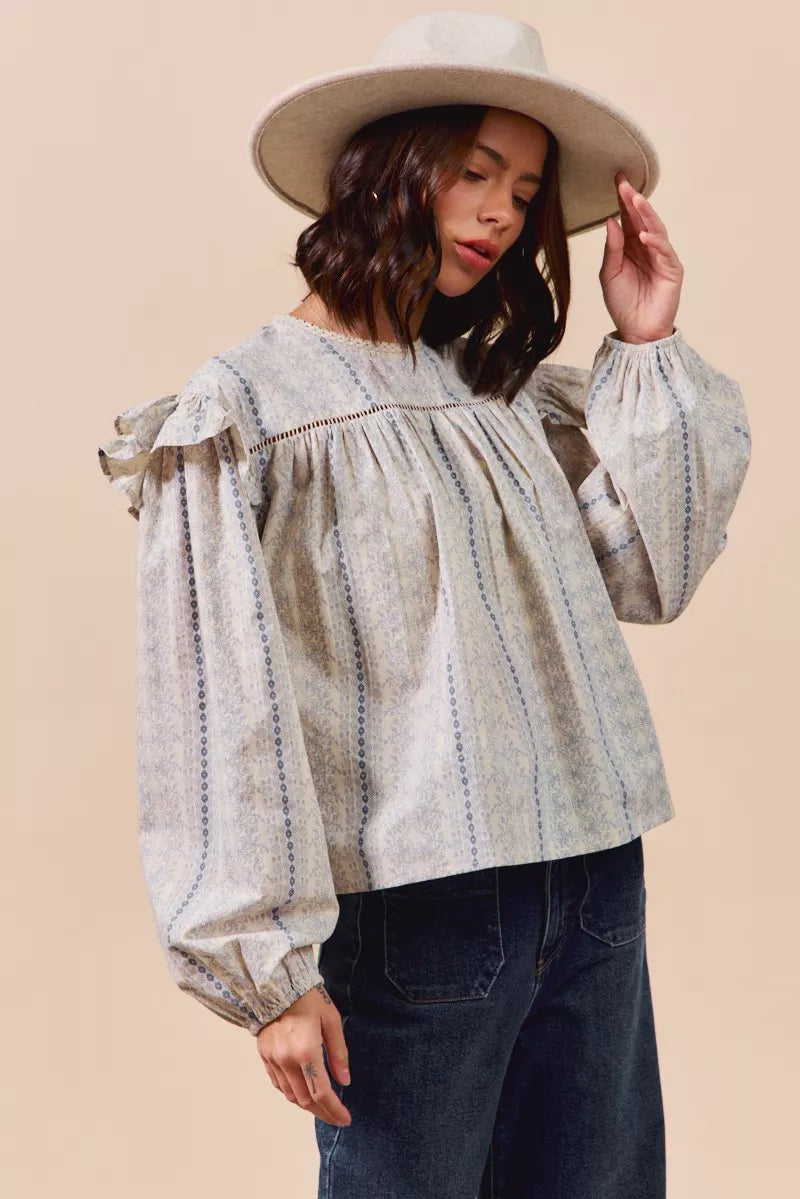 Blue floral cotton print ruffled long sleeve blouse by Trendsi, featuring feminine design and lightweight fabric.