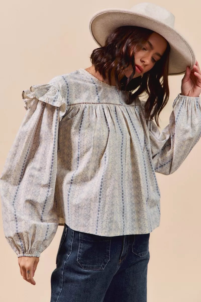 Blue floral cotton print ruffled long sleeve blouse from Trendsi, featuring a stylish and feminine design.