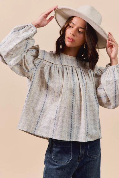 Blue floral cotton print ruffled long sleeve blouse by Trendsi, featuring feminine design and lightweight fabric.