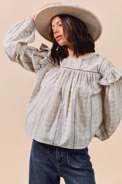 Blue floral cotton print ruffled long sleeve blouse by Trendsi, featuring feminine ruffle details and a comfortable cotton fabric.